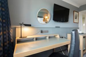 卡迪夫假日加的夫城市酒店的客房设有一张带电视和镜子的书桌。
