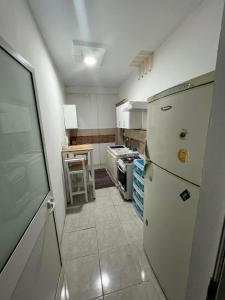 Bir KassaAppartement au calme的带冰箱和桌子的厨房