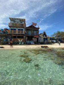 布兰卡滩Mi Cabañita Guest House的海滩上的一座建筑,水面在前面