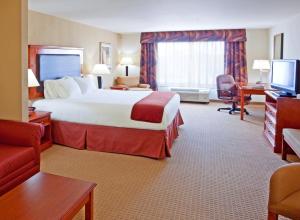 莱瑟姆Holiday Inn Express & Suites Albany Airport Area - Latham, an IHG Hotel的酒店客房设有一张大床和一台电视。