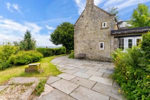 马特洛克Peak District Break in Cottage with Great Views的享有石头房子外景,设有天井