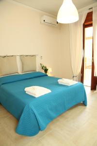 里波斯托Casa A Riba U Mari的蓝色的床,上面有两条毛巾