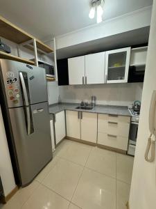 内乌肯Departamentos Leloir的厨房配有不锈钢冰箱和白色橱柜