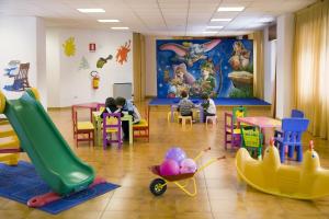 拉特乌伊莱TH La Thuile - Planibel Residence的一间教室,里面放着儿童坐在桌子和幻灯片上