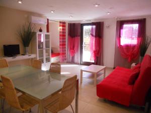 马达莱纳博尔戈普塔别墅旅馆的客厅配有桌子和红色沙发