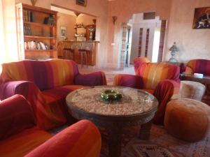 瓦尔扎扎特图尔马琳住宿加早餐旅馆的客厅配有五颜六色的椅子和桌子