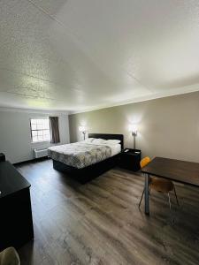 黑泽尔伍德Motel 6-Hazelwood, MO的一间卧室配有一张床和一张桌子