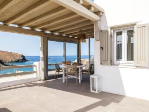 Merchia BeachSundance Suites Mykonos的一个带桌椅的海景庭院