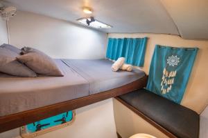 El PorvenirEnjoy San Blas sailing的配有蓝色窗帘的拖车内的两张单人床