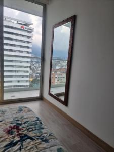 基多Suite Martina 2 Personas Quito的市景客房的镜子