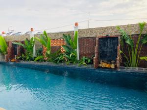 会安Aqua Villa Hoi An - River view & walkin to beach的砖楼前的游泳池