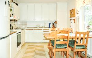 赛夫勒Nice Home In Sffle With House A Panoramic View的厨房配有白色橱柜和木桌及椅子