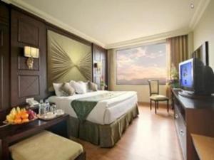 KalanganHotel Utami的酒店客房设有一张大床和一台电视。