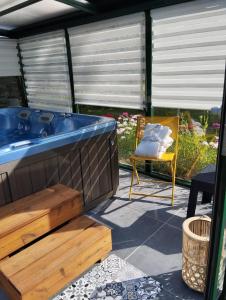 La Chapelle-aux-BoisL'Appart的庭院内的热水浴池和椅子