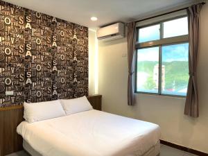 绿岛星月屋渡假山庄 的一间卧室设有一张床,墙上设有窗户