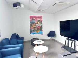 克莱蒙费朗Auberge de jeunesse HI Clermont-Ferrand的客厅配有蓝色的沙发和平面电视。