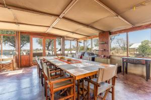 曼耶雷蒂野生动物园Buffelshoek Tented Camp的大型用餐室配有长桌和椅子