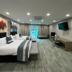 MacutoHotel Vip La Guaira的大型酒店客房设有两张床和一张书桌