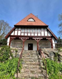 赫亨基尔兴Großes Ferienhaus an der Ostsee "Oldevighus"的房屋,设有通往大楼的楼梯