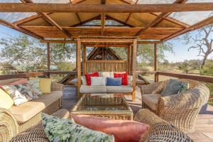 曼耶雷蒂野生动物园Buffelshoek Tented Camp的一个带柳条家具和凉亭的户外庭院