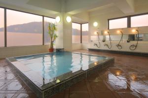 德岛德岛阳光酒店的一个带窗户的房间,有一个大型游泳池
