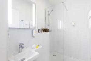 日内瓦日内瓦中心一室公寓的白色的浴室设有水槽和淋浴。