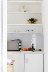 日内瓦日内瓦中心一室公寓的厨房配有微波炉和一盘水果及蔬菜