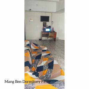 马尼拉Mang Ben Dormitory Pasay的一间带一张床铺的卧室,位于带书桌的房间