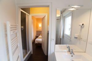 拉尼翁BRIT HOTEL Lannion Perros的一间带水槽和镜子的浴室