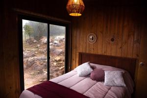 塞拉纳镇El Secreto en las Sierras的一间卧室设有一张大床和大窗户