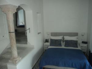 西迪·布·赛义德La Villa Bleue-Sidi Bou Said的一间卧室配有蓝色的床和镜子