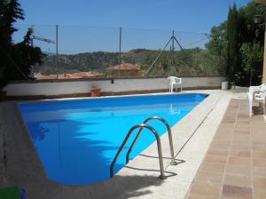 塞内斯德拉韦加卡萨加利亚度假屋的蓝色游泳池旁边设有金属栏杆
