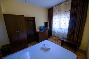 皮特什蒂Pensiunea Domneasca的客房设有床、书桌和窗户。