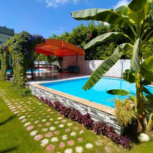 Qaryat ShākūshTwo pools four bedrooms private villa的一座房子旁的院子内的游泳池