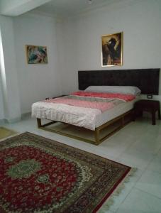 Qaryat ShākūshTwo pools four bedrooms private villa的一间卧室,卧室内配有一张床和地毯