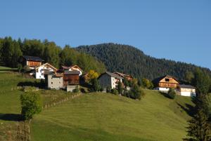 安特尔莫伊亚Hotel Pütia的山丘上的一个村庄,有绿草和树木