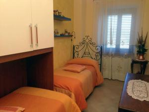 阿尼奥内伊尔巴格利沃公寓的一间卧室设有两张带橙色床单的床和窗户。