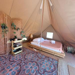 布劳沃斯港Buitenplaats de Oorsprong的一间卧室,配有带一张床和地毯的帐篷
