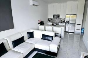 Long Bay HillsApartment Condominium Grace Bay Beach的一间带白色沙发的客厅和一间厨房