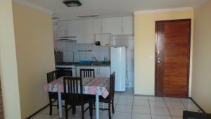 福塔莱萨Emilio Hinko 3 Quartos apto1502的厨房配有桌椅和冰箱。