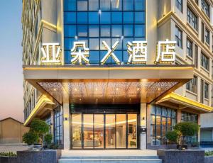 花都Atour X Hotel Guangzhou Baiyun Airport Huadong Chaoyang Road的前面有标志的建筑