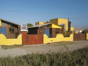 拉塞雷纳Cabañas Caleta San Pedro的一排房屋,有黄色的墙壁和栅栏