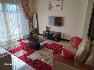 KigoFully furnished 3 bedroom apartment in Mirembe Villas Kigo, Uganda的带沙发和平面电视的客厅