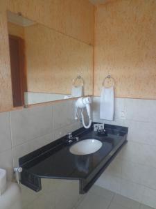 马卡帕马格努斯广场酒店的一间带水槽和镜子的浴室