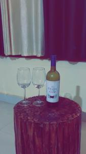 莫尔吉姆Vyana villa rooms的桌子上放有一瓶葡萄酒和两杯酒