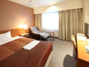 盛冈盛冈珍珠城市饭店的配有一张床和一把椅子的酒店客房
