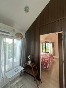 大城Tiny home by the River in Thailand的一间卧室配有一张床、一张桌子和一面镜子