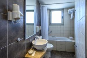 海若克利欧Marin Hotel的浴室配有盥洗盆、卫生间和浴缸。