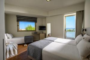 海若克利欧Marin Hotel的酒店客房设有两张床和窗户。