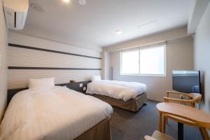 札幌The Stay Sapporo Annex的酒店客房设有两张床和电视。